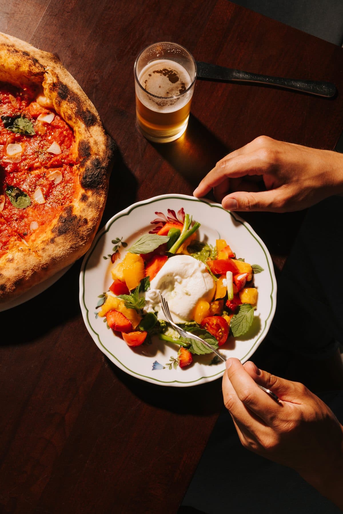A table with pizza, salad and an Aperol at PIENO